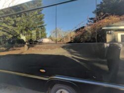 The Napa Valley vineyards reflect on the side of the Mercedes Sprinter of Master Wine Tours, Napa valley.